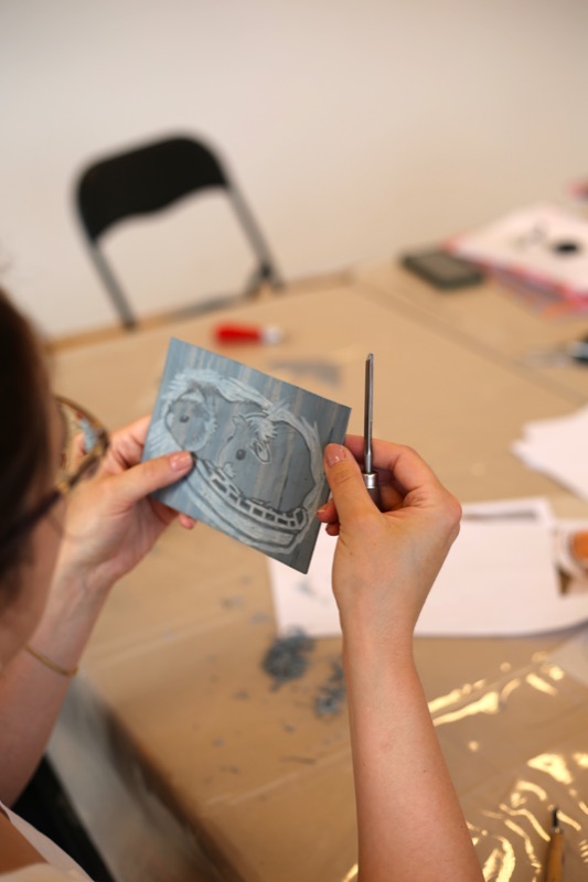 Uczestniczka ogląda gotową matrycę z portretem dwóch kotów